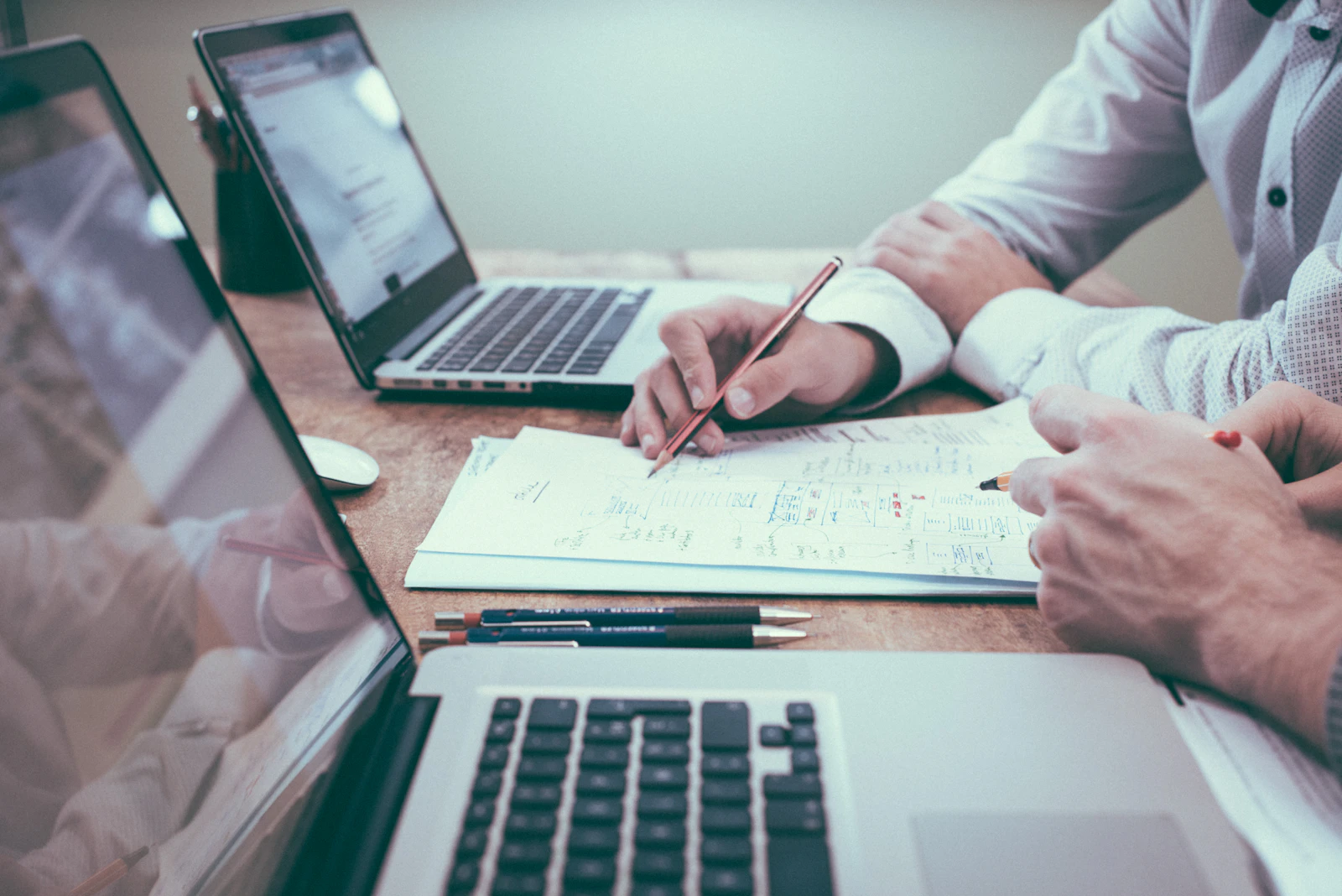 Equipe analisando documentos e projetos técnicos sobre a mesa