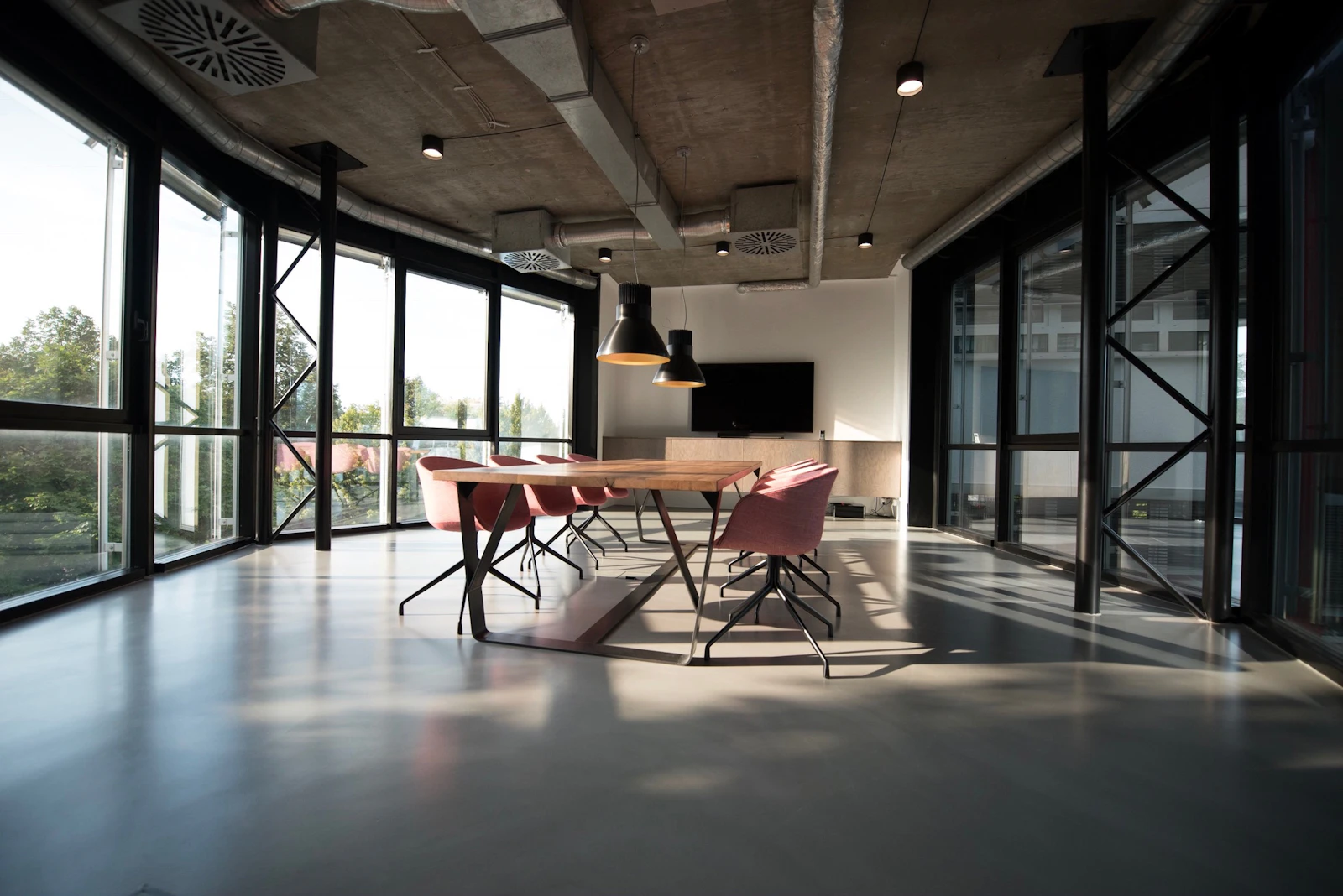 Sala de reuniões moderna com mesa de madeira e cadeiras, ambiente de escritório de arquitetura