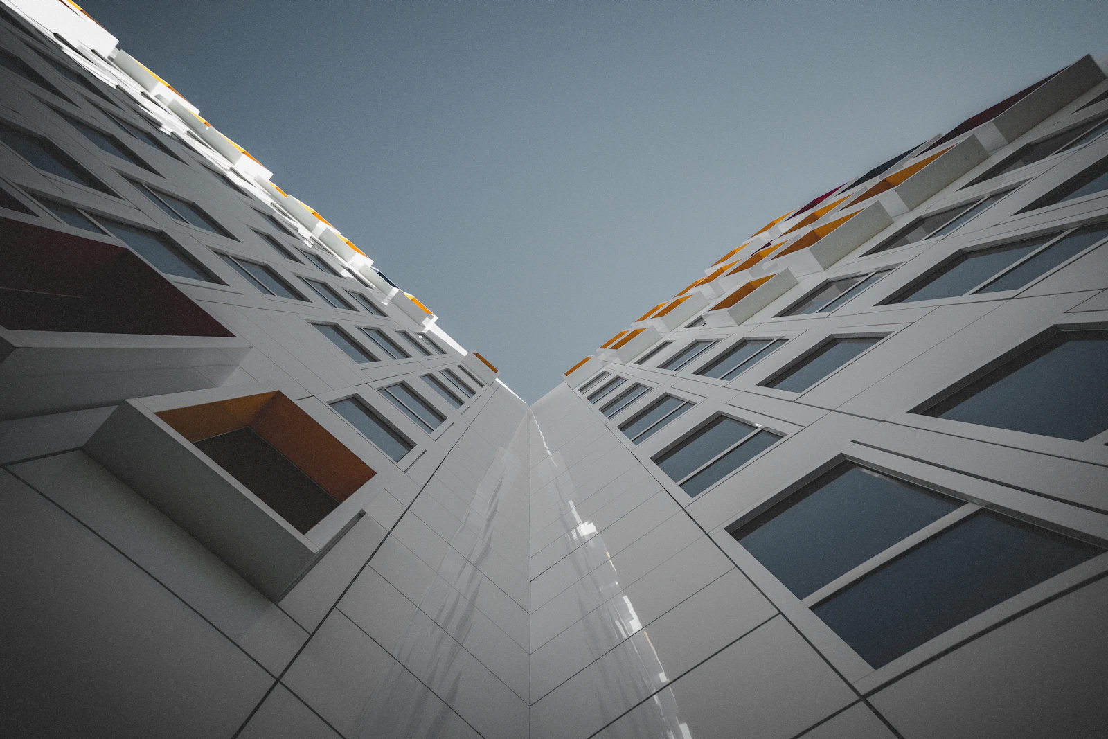 Fachada de edifício moderno visto de baixo para cima, com linhas geométricas