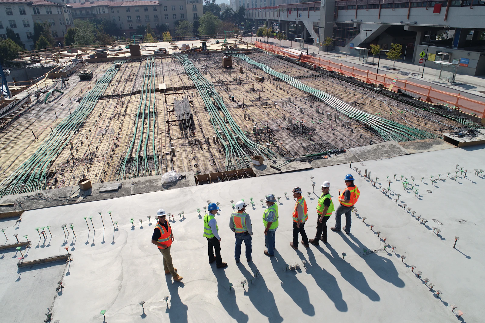 Equipe de obra utilizando capacetes e coletes de segurança em canteiro de construção
